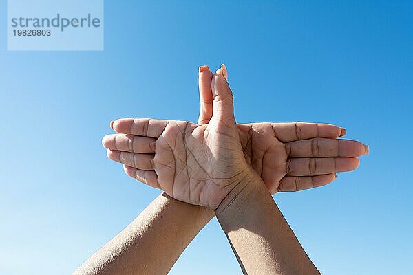 Frau die Hände machen Taube Zeichen mit ihren Händen gegen blauen Himmel