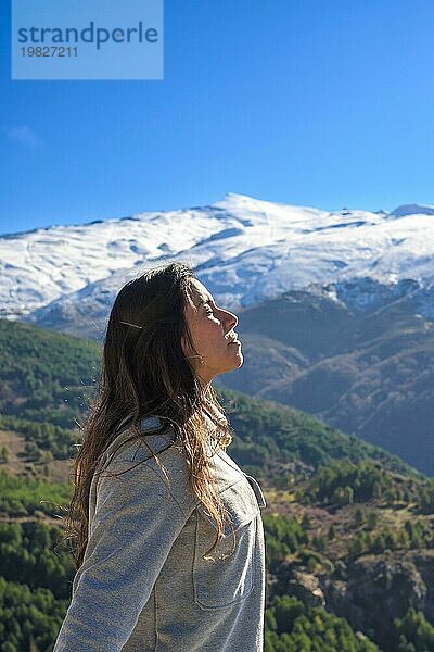 Latina Frau  lange Haare  atmet frische Luft auf dem Gipfel des Berges  sierra nevada spanien