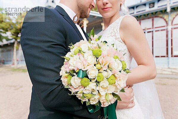 Porträt einer Hochzeit Bouquet auf dem Hintergrund Ein schönes Paar von Jungvermählten  die umarmt vor dem Hintergrund der Vintage Gebäude der Ausstellung Galerie steht. Das Konzept eines Hochzeitsspaziergangs und Familienglück in einer Ehe. Nahaufnahme