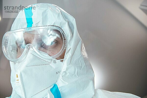 Medizinischer Laborant im Chemikalienschutzanzug und mit Schutzbrille