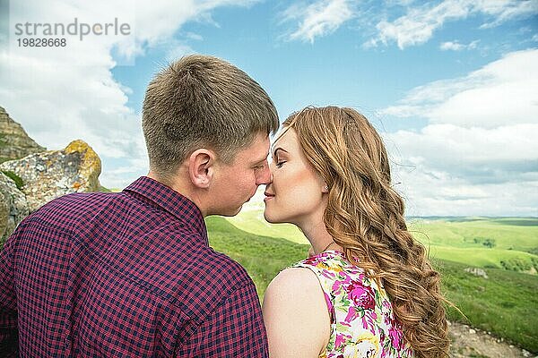 Ein junges Ehepaar reicht sich vor dem Hintergrund einer wunderschönen Natur die Hand zum Kuss. Konzept einer glücklichen jungen Familie