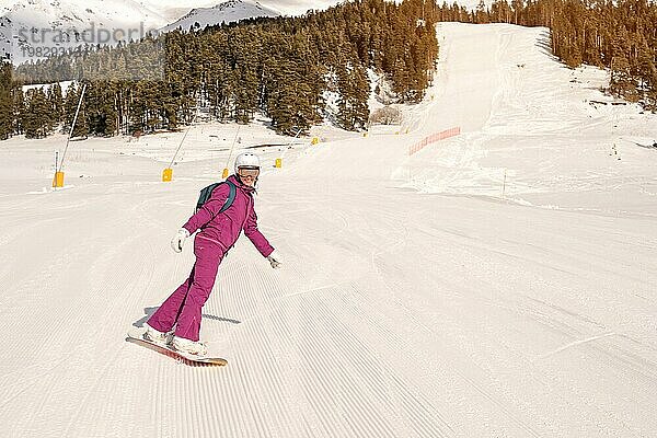 Schöne Anfängerin Snowboarderin in den kaukasischen Bergen