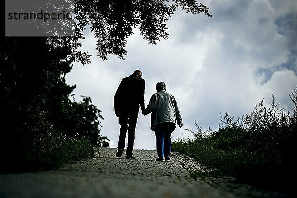 Symbolfoto zum Thema Rentner. Ein altes Ehepaar lüftet bei einem Spaziergang gemeinsam einen Weg entlang. Berlin  30.08.2023