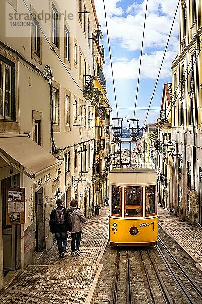 Lissabon  Portugal  29. März 2018: Menschen und gelbe Standseilbahn Straßenbahn  Symbol von Lissabon und Innenstadt Straße Perspektive  Europa