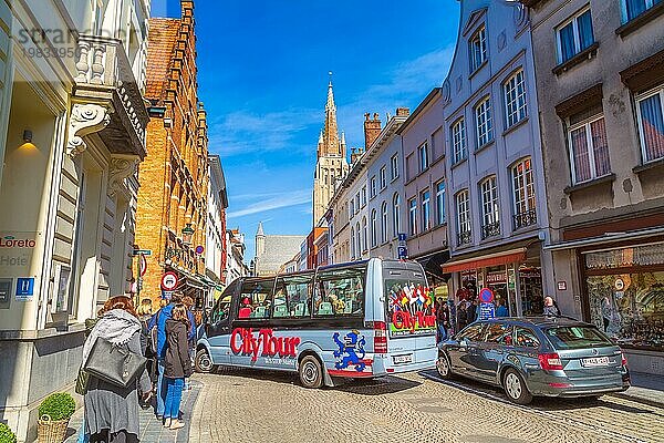 Brügge  Belgien  10. April 2016: Straßenansicht mit buntem Hop on hop off Sightseeing Tours Bus und traditionellen Häusern  Menschen  Europa