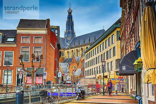 Haarlem  Niederlande  2. April 2016: Straßenansicht mit Menschen  Fahrrädern und Kathedrale in Haarlem  Holland  Europa
