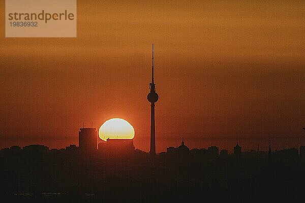 The television tower is silhouetted against the rising sun in Berlin  06/09/2023