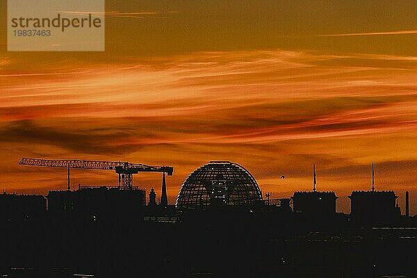 Die Silhouette der Reichstagskuppel zeichnet sich ab vor der Abenddämmerung in Berlin  04.09.2023