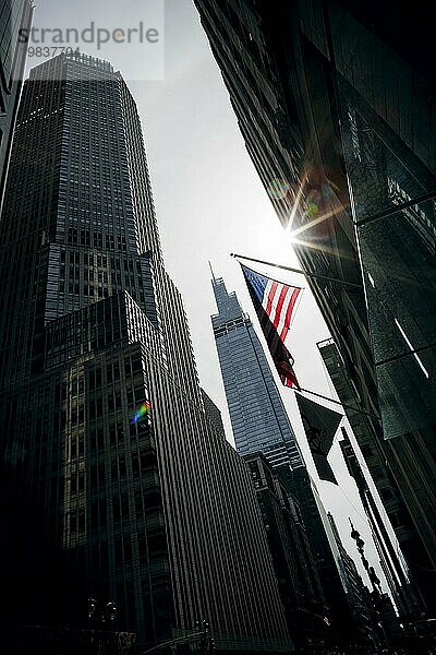 Street scene in New York City. The sun shines on an American flag. New York City  16.09.2023