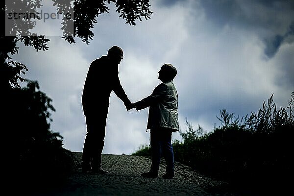 Symbolfoto zum Thema Rentner. Ein altes Ehepaar lüftet Hand in Hand bei einem Spaziergang gemeinsam einen Weg entlang. Berlin  30.08.2023