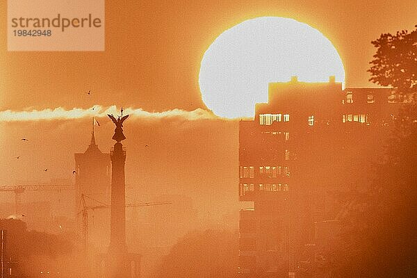 The pillar of victory looms in front of the rising sun in Berlin  14/09/2023