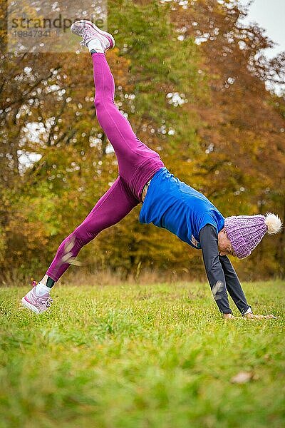 Fitnessbegeisterte Frau praktiziert Handstand draußen  von Herbstfarben umgeben  Gechingen  Schwarzwald  Deutschland  Europa