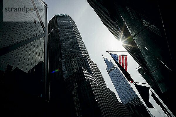 Street scene in New York City. The sun shines on an American flag. New York City  16.09.2023