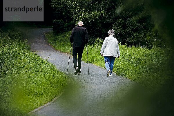 Symbolfoto zum Thema Rentner. Ein altes Ehepaar lüftet bei einem Spaziergang gemeinsam einen Weg entlang. Berlin  30.08.2023