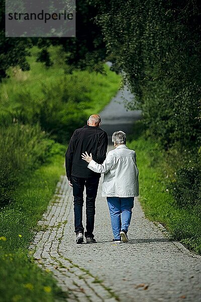 Symbolfoto zum Thema Rentner. Ein altes Ehepaar lüftet bei einem Spaziergang gemeinsam einen Weg entlang  wobei die Frau ihren Mann unterstützt. Berlin  30.08.2023