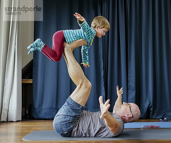 Topic: Grandfather doing gymnastics with his four-year-old grandchild