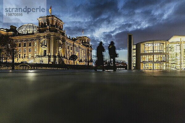 Two people stand out in front of the German Bundestag at blue hour in Berlin  15/11/2023