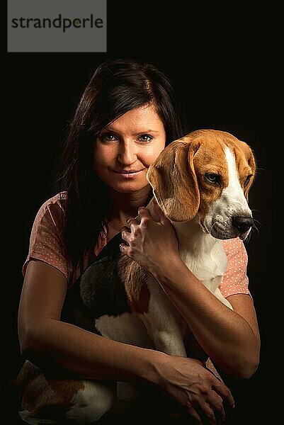 Glückliche Frau  die einen Beagle Hund umarmt. Hundefreund