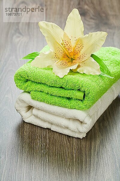 Blume auf Handtüchern auf hölzernem Hintergrund