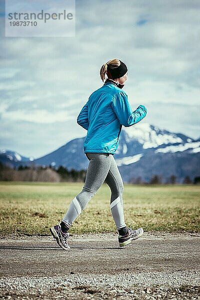 Junge Frau joggt  Landschaft