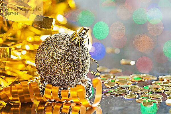 Goldfarbene Weihnachtskugel mit Schnur auf dem Hintergrund von Bokeh horizontale Version