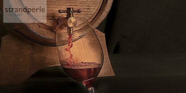 Einschenken von Wein in ein Glas aus einem Eichenfass  ein getöntes Panorama auf dunklem Hintergrund mit Kopierraum