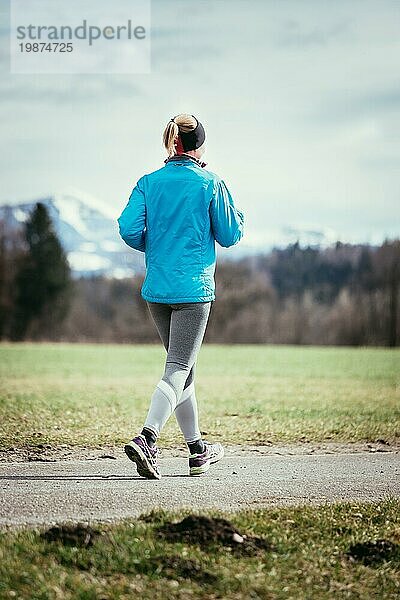 Junge Frau joggt  Landschaft