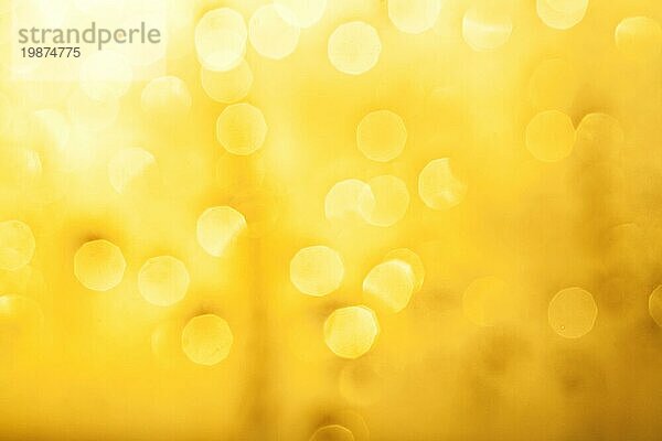 Goldenes Bokeh von Wassertropfen auf Fenster