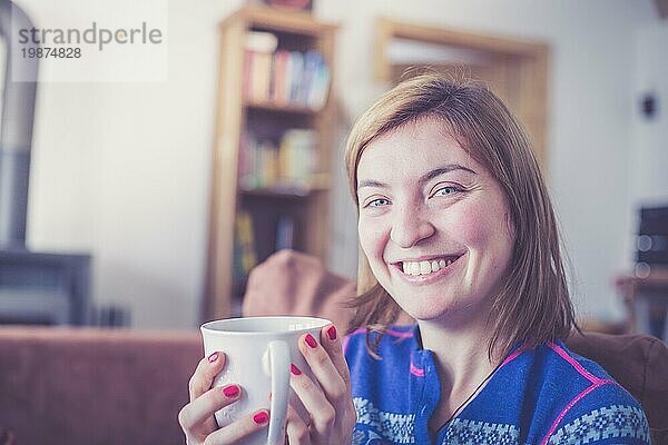 Schöne junge Frau genießt eine Tasse Tee