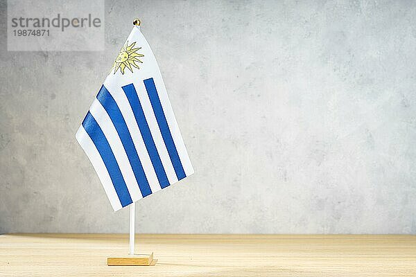 Uruguay Tischflagge auf weißer  strukturierter Wand. Kopierraum für Text  Entwürfe oder Zeichnungen