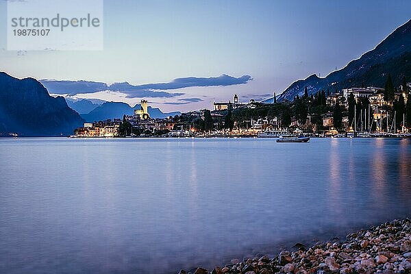 Schöne Abendstimmung am Strand mit niedlichem kleinen Dorf  Gardasee  Italien  Europa