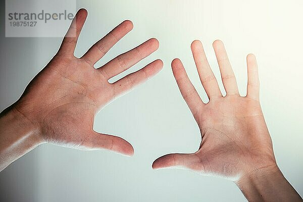 Junge männliche Hände machen eine heilende oder schützende Geste