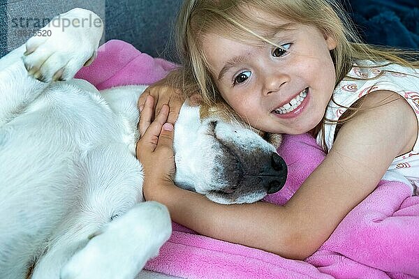 Happy Child kuscheln ein Beagle Hund bester Freund auf dem Sofa. Hund und Kinder Konzept