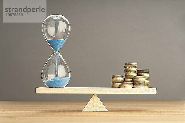 Balance zwischen Zeit und Geld Konzept. Sanduhr und gestapelte Münzen auf Wippe. Raum kopieren