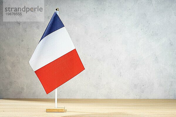 Frankreich Tischflagge auf weißer Strukturwand. Kopierraum für Text  Entwürfe oder Zeichnungen