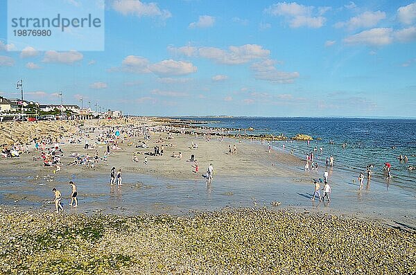 Galway  Irland  09.08.2012: Blick auf einen Strand voller Menschen an einem sonnigen Sommertag. Blaür Himmel mit ein paar Wolken und ruhiges Meer. Touristischer Ort  sehenswerter Ort  Europa
