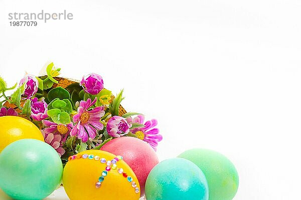 Ostern bunte Eier auf weißem Hintergrund mit Blumenstrauß Großaufnahme  Kopie Raum