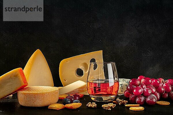Käse und Wein  eine Seitenansicht auf schwarzem Hintergrund mit Leerzeichen