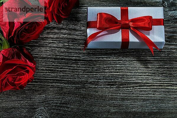 Weißes Geschenkbox natürliche rote Rosen auf Holzbrett