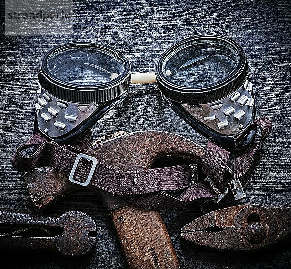 Schutzbrille Hammerzange auf altem Holzbrett