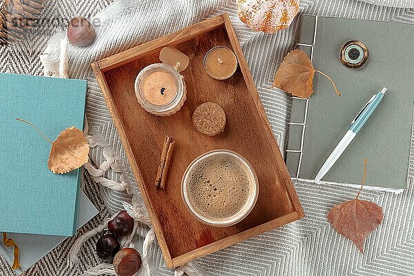 Hygge. Herbststillleben mit Kaffee  Kerzen  Herbstblättern  einer Zeitschrift und einigen Büchern  Overhead Flat Lay Aufnahme