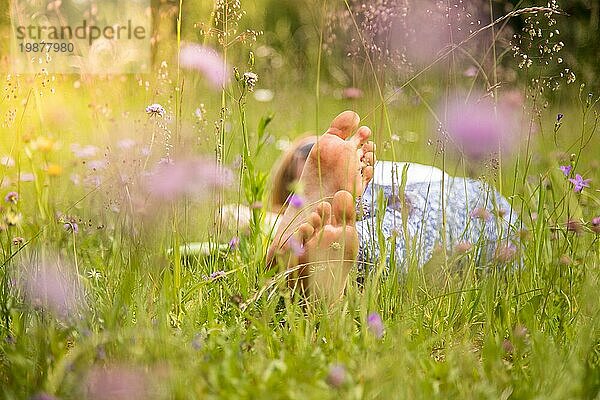 Junges Mädchen im Park liegt im Gras und genießt den Tag