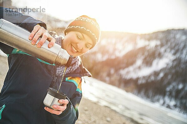Schönes kaukasisches Mädchen hält eine Tasse Tee im Freien  Winterzeit