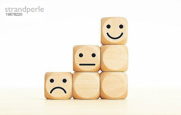 Bewertung der Kundenerfahrung  Konzept der Zufriedenheitsumfrage. Holzblöcke mit Emoticon. Kopieren Raum