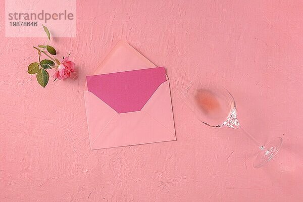 Grußkarte  Valentinstag oder Einladung Mockup  ein Flatlay mit einer rosa Rose und Wein  Overhead Flat Lay Schuss auf einem rosa Hintergrund  getönten Bild