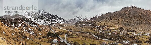 Ein Panoramabild des Kazbegi Gebirges an einem nebligen Tag