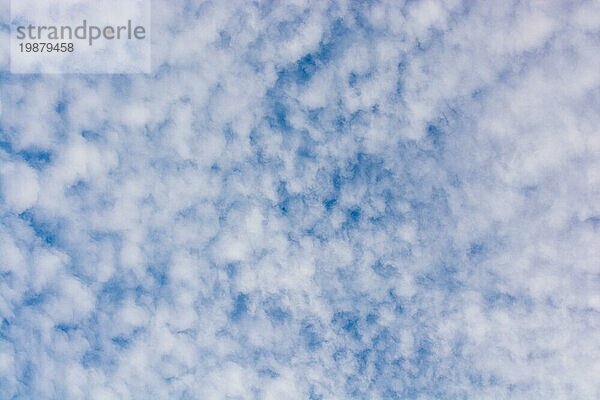 Weiße Farbwolken bedecken den blaün Himmel am Tag