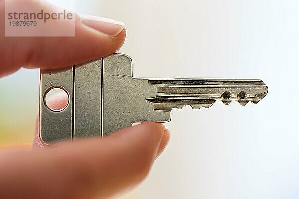 Einen Hausschlüssel in der Hand halten: Neues Zuhause und Eigentum