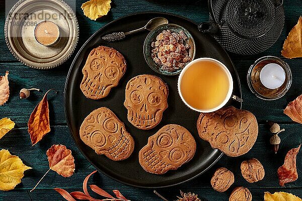 Halloween Ingwerplätzchen in Form von Totenköpfen  hausgemachte Dia de los muertos Kekse  von oben auf einen dunklen Holzhintergrund geschossen