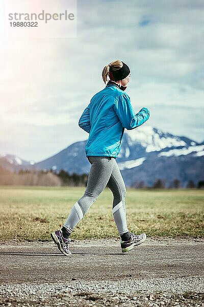 Junge Frau joggt  Landschaft